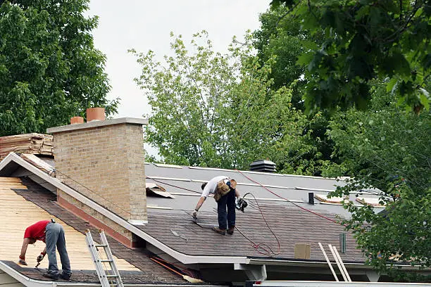 Experienced roofer examining flashing details and roof wear with trained precision