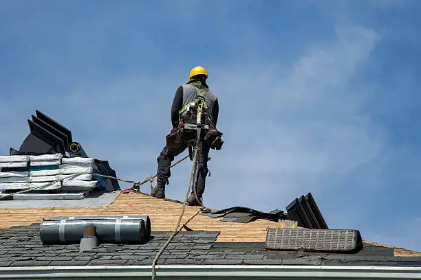 Roofing crew reviewing repair plan on a residential roof in Allen