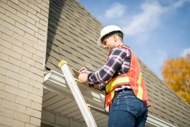 Experienced roofer examining flashing and roof condition with professional precision